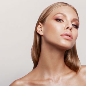 Beauty portrait of model with natural make-up. Fashion shiny highlighter on skin, sexy gloss lips make-up